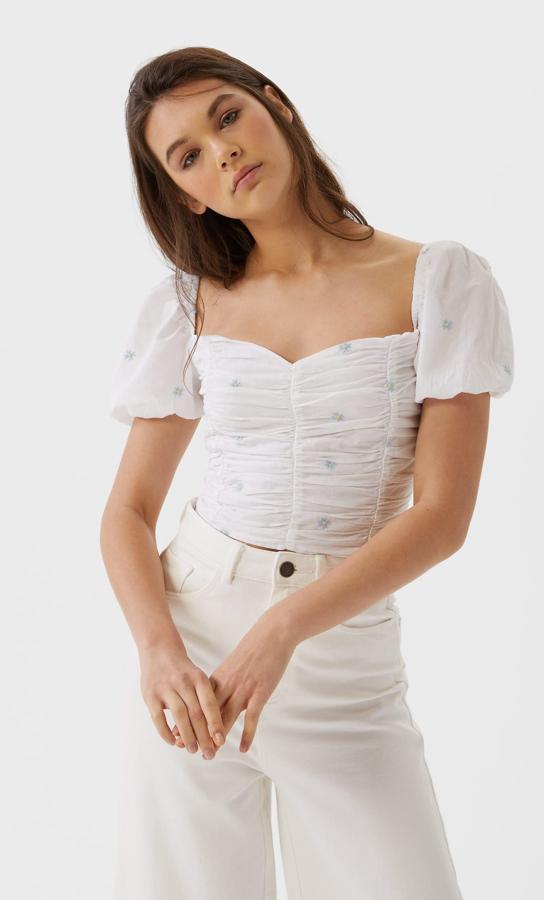 Top drapeado blanco con bordados, de Stradivarius (19,99 euros).