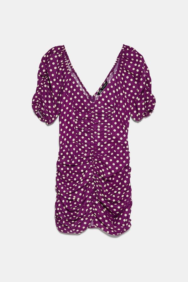 Este vestido confeccionado en mezcla de lino en color morado con topos blancos es de Zara. Con manga abullonada y tejido drapeado, tiene un precio de 29,95 euros.