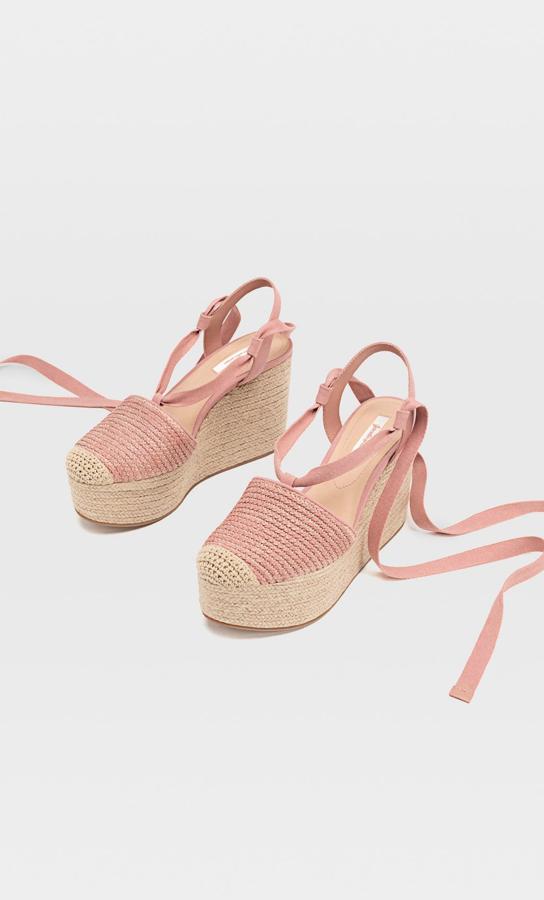 En color rosa con contraste en la puntera, estas cuñas de yute atadas al tobillo cuentan con una altura de diez centímetros. Tienen un precio de 29,99 euros.