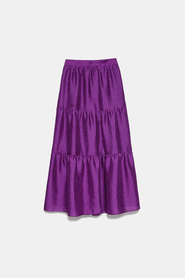 De línea evasé, con volantes estructurados y en color morado, esta vistosa falda midi con volumen es de Zara y cuesta 39,95 euros. Está disponible entre las tallas XS y XXL.