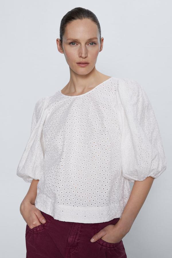 Blusa blanca de manga corta con calados que hacen el efecto de flores y la espalda baja, de los Special Prices de Zara (15,99 euros).