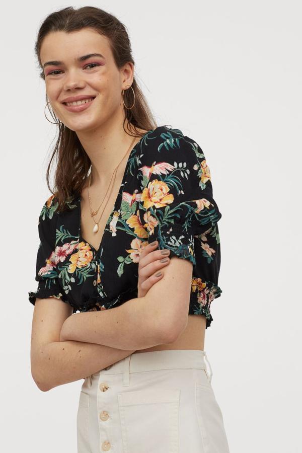 En versión cropped de viscosa arrugada, este top de H&M con escote de pico profundo viene con un bonito estampado floral de fondo negro y motivos en tonos rosas y naranjas. Con fruncido ancho en mangas y bajo, cuesta 19,99 euros y está disponible entre las tallas 32 y 40 y en la 48, aunque esta última se está agotando.