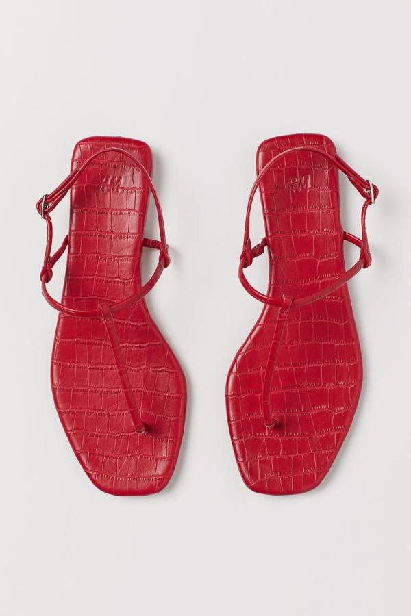 En color rojo con efecto piel de cocodrilo (aunque también las encontramos en color rosa magenta), estas sandalias planas con hebilla lateral de cierre tienen un precio de 19,99 euros.