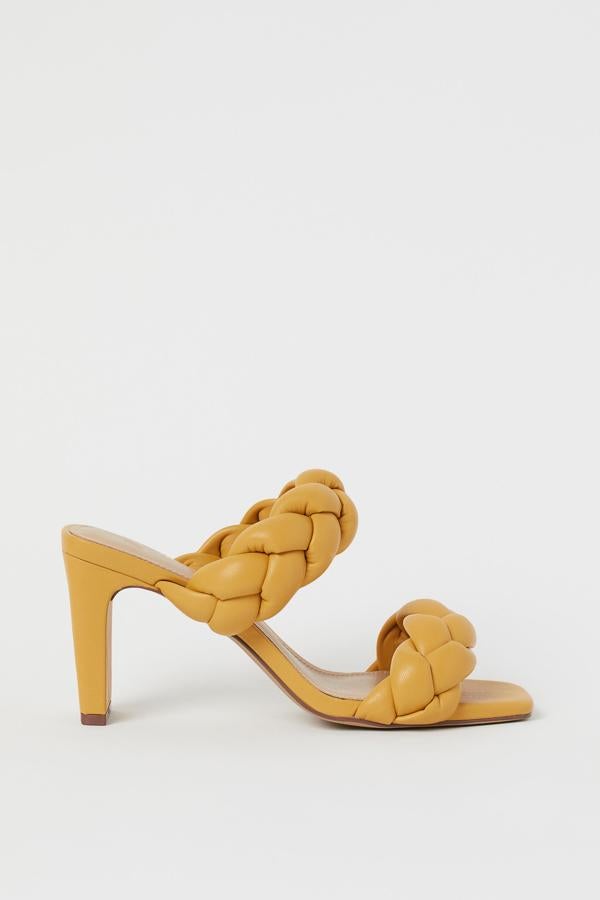 En color amarillo mostaza, estas sandalias de piel sintética con tiras acolchadas trenzadas cuentan con puntera cuadrada abierta y tacón revestido. Tienen un precio de 29,99 euros.