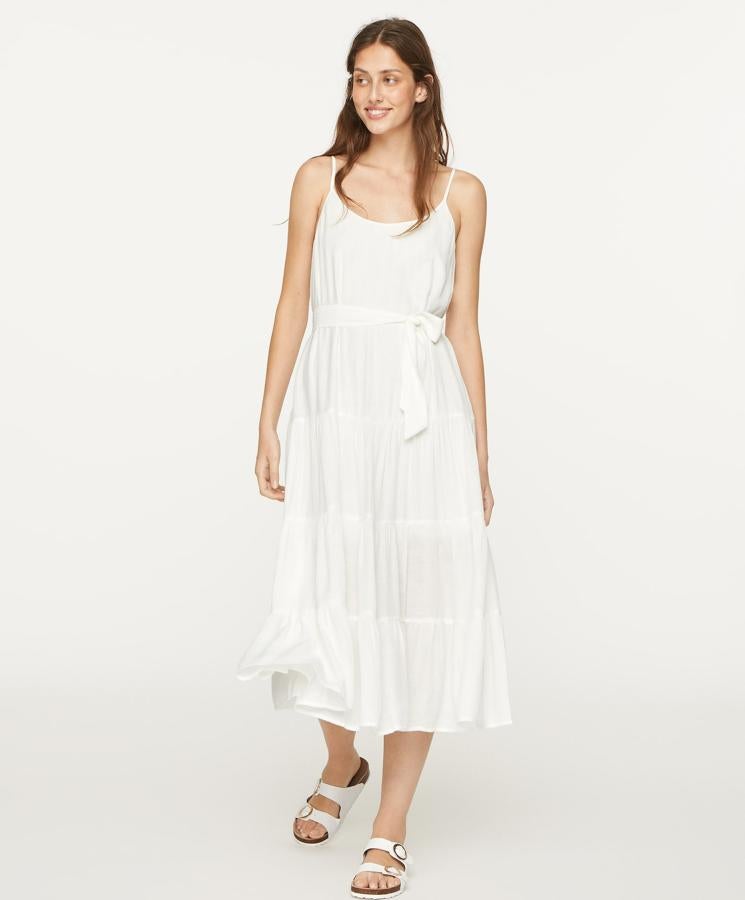 Los vestidos blancos son un imprescindible del verano. Como este, de tirante fino y lazada para ceñir la cintura, que tiene un precio de 35,99 euros.