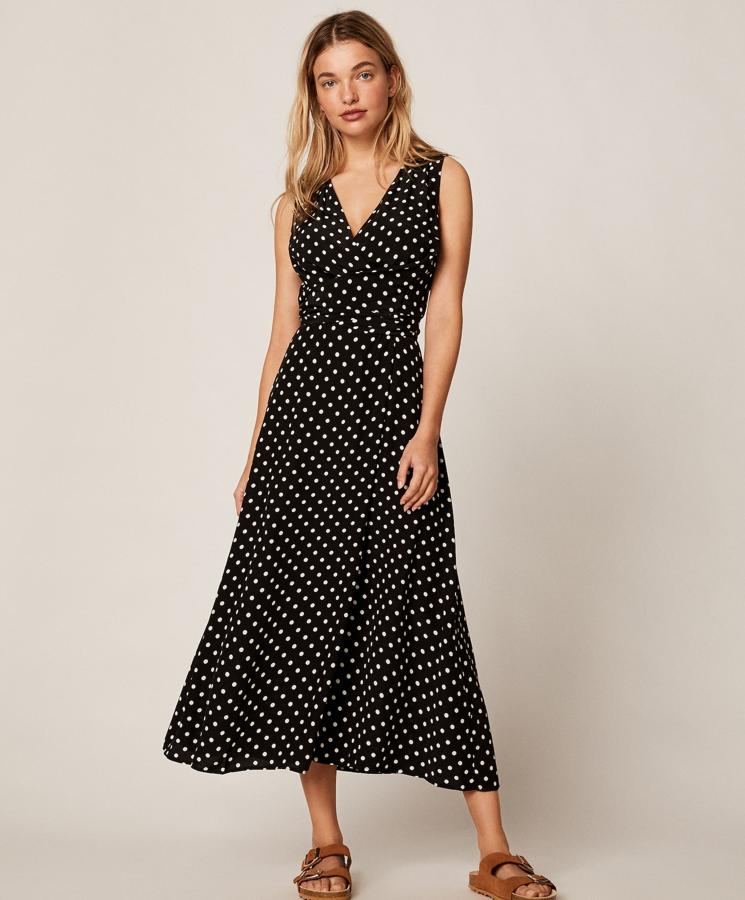 Si aún no has sucumbido a los lunares, este es tu momento. Con escote de pico y de tirantes, este vestido negro con topos en blanco, cuenta con lazada para ceñir la cintura y tiene un precio de 35,99 euros.