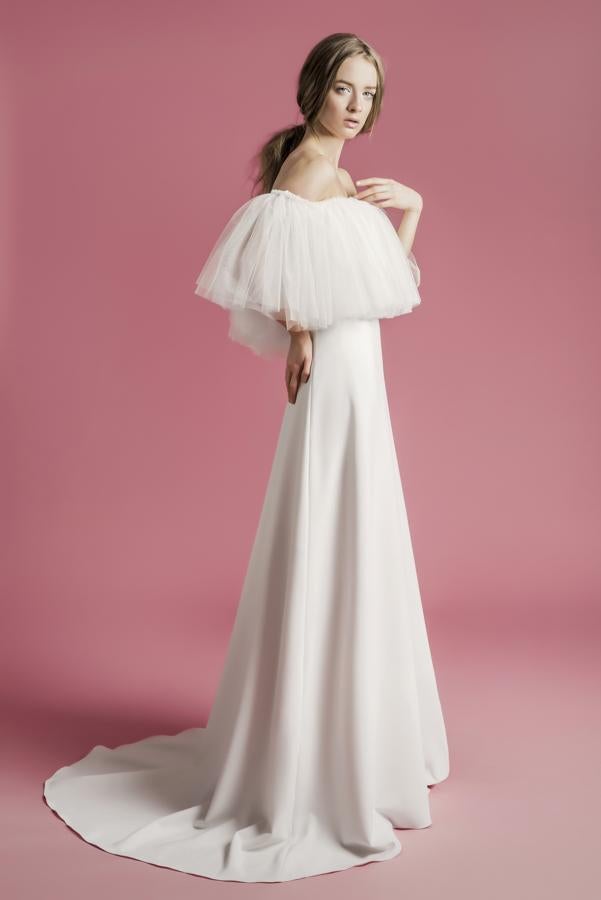 Vestido de novia largo con cola redonda y escote barco con volantes de tul.