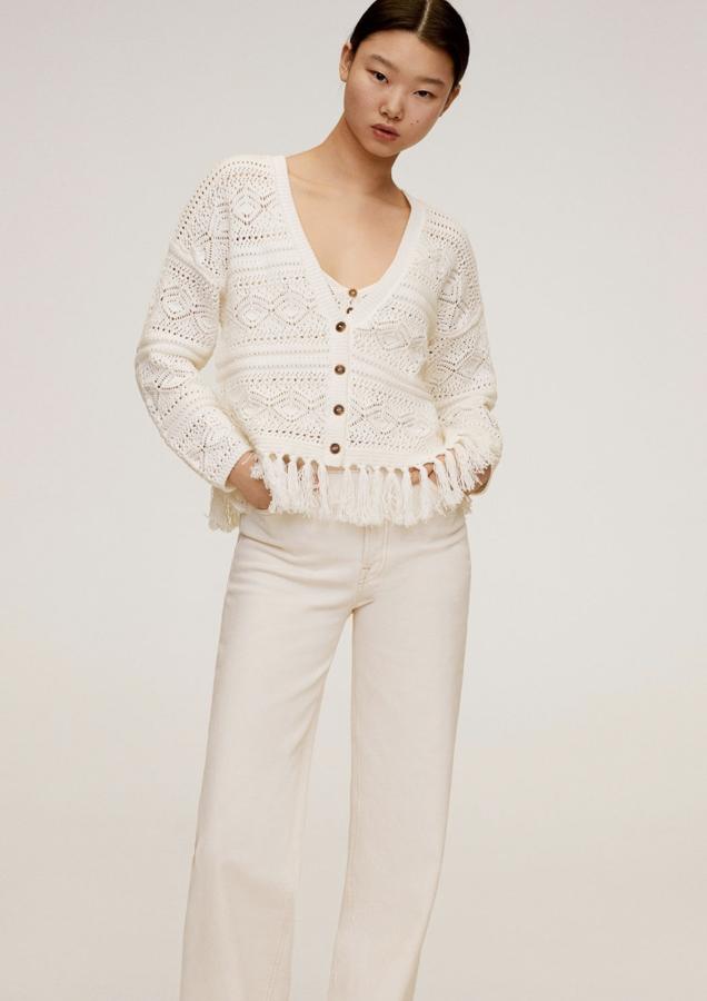 En color blanco, este cárdigan de crochet con diseño corto y cuello de pico es de Mango. Con terminación de flecos y cierre de botones en la parte delantera, tiene un precio de 29,99 euros.