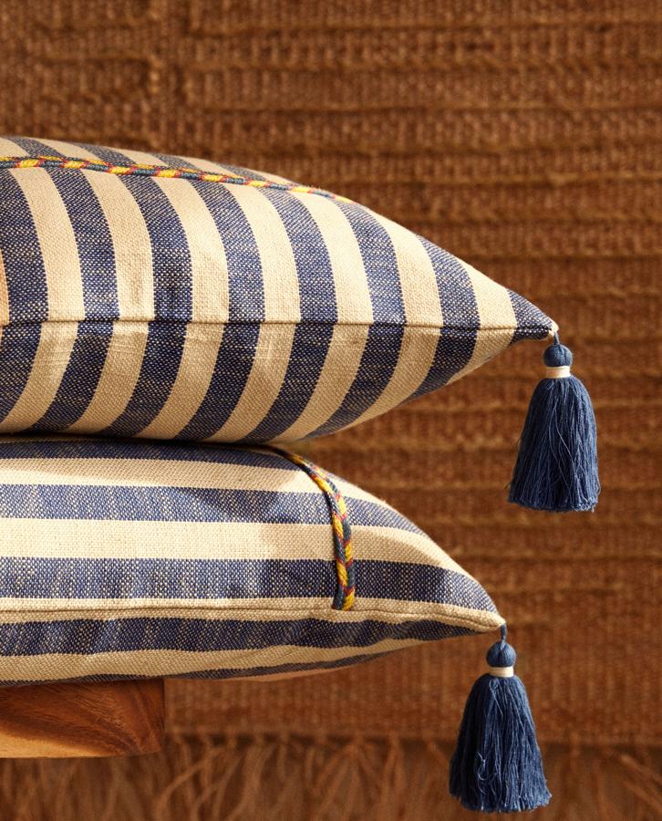 De rayas en azul y blanco con pompones, esta funda de cojín de algodón cuenta con cierre con cremallera. Con medidas de 45x45 centímetros, tiene un precio rebajado de 15,99 euros.