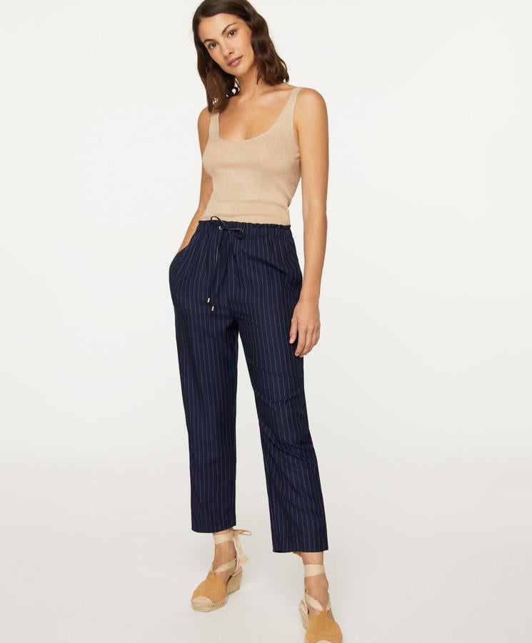 En color azul marino con rayas finas en blanco, este pantalón largo ajustable a la cintura mediante goma elástica y cordón es de Oysho y tiene un precio de 19,99 euros.