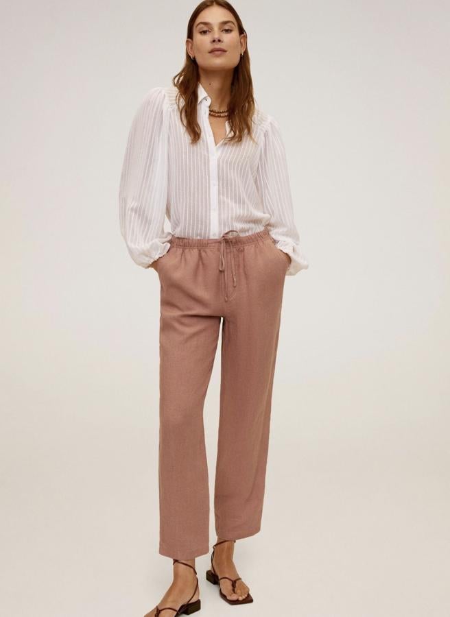 En color rosa, estos pantalones rectos de lino de Mango están disponibles en varios colores y estampados. Con cintura elástica y bolsillos, tienen un precio de 25,99 euros.
