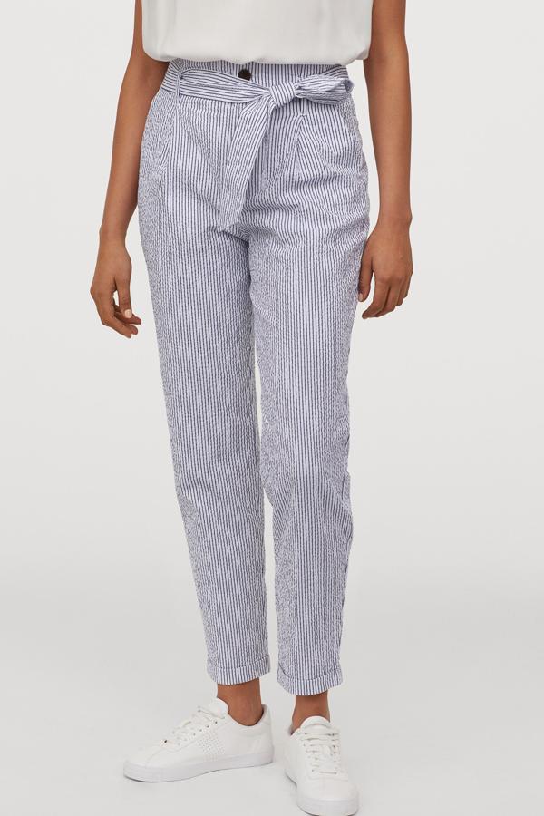 Este pantalón tobillero de algodón en blanco con rayas azules cuenta con cinturón extraíble y bajos vueltos cosidos. Es de H&M y tiene un precio de 29,99 euros.