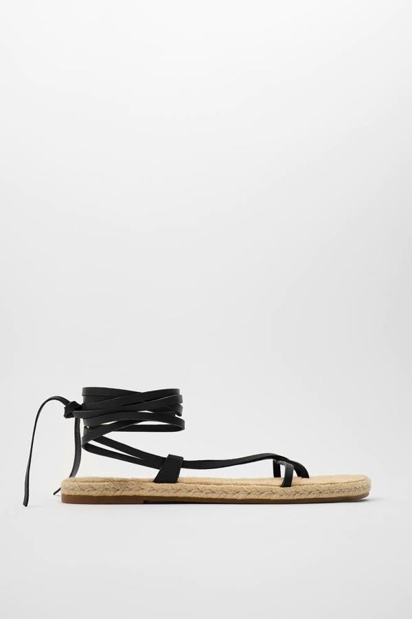 Con tiras para atar alrededor del tobillo, estas sandalias planas de piel en color negro (también disponible en marrón) cuentan con plataforma y planta forrada de yute. Son de Zara y tienen un precio de 29,95 euros.