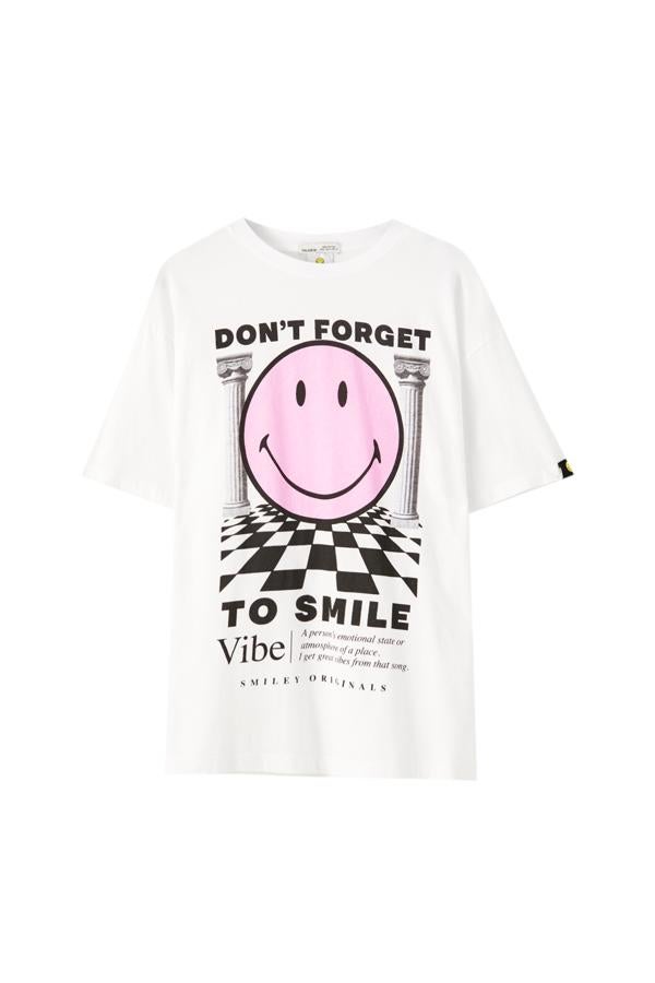 Con texto motivador a contraste y Smiley entre columnas y cuadros en color rosa, esta camiseta de cuello redondo y manga corta cuesta 14,99 euros y está disponible entre las tallas XS y XL.