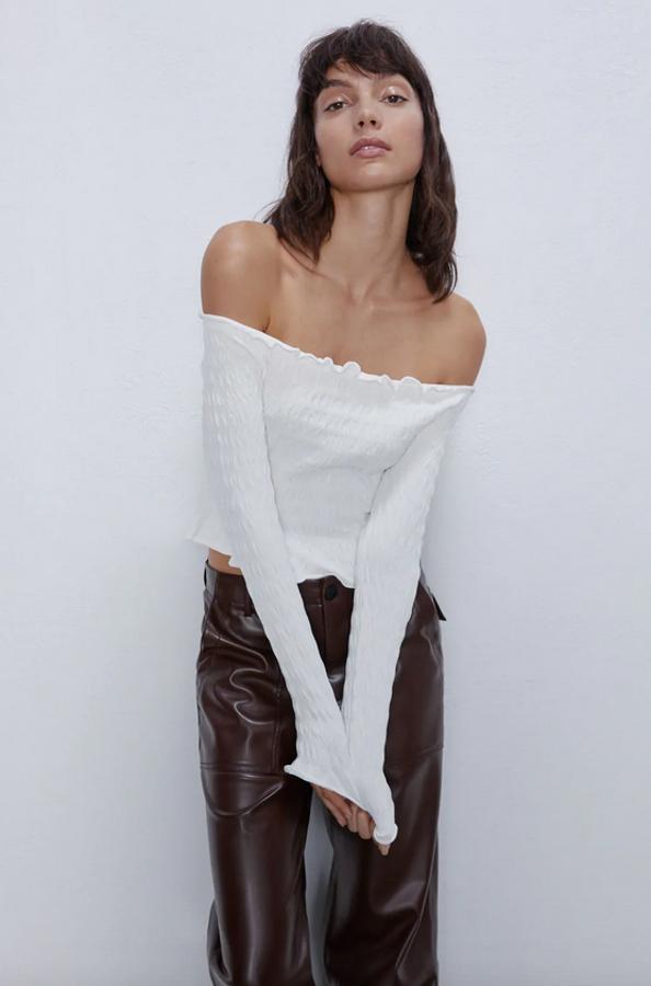 Hombros al aire y mangas largas para este top con escote recto amplio y acabados en volantes. Cuesta 19,95 euros y está disponible en las tallas M y L, y en los colores caqui y negro.