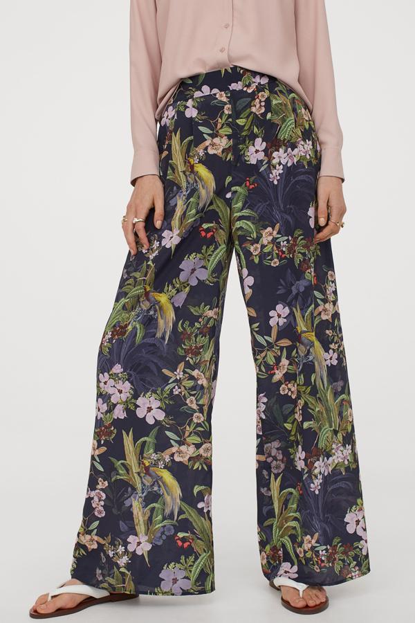 Pantalones de corte palazzzo, con estampado de flores sobre fondo azul marino, de H&M (29,99 euros).