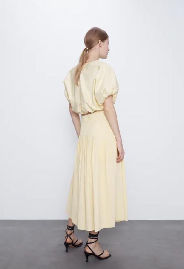 El amarillo claro es uno de los colores que va a arrasar este verano. Si te gusta, échale el ojo a este cuerpo corto de cuello redondo y manga corta abullonada con acabados elásticos y cierre en espalda con abertura y botón. Tiene un precio de 22,95 euros, es Join Life y lleva falda a juego.