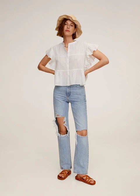 Con volantes en las mangas y en el color tendencia de la temporada el blanco. Encuentra esta blusa en las novedades de Mango. (25,99 euros).