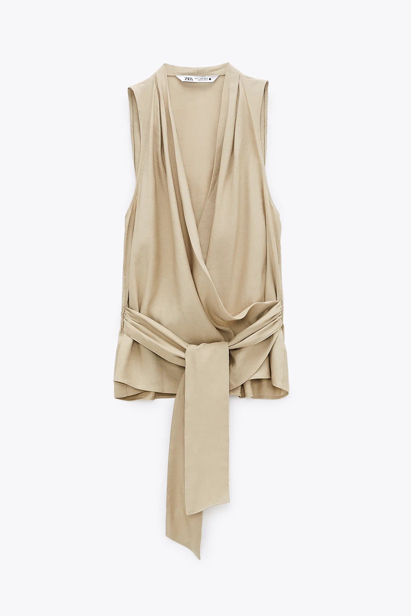 La más favorecedora: blusa cruzada con lazada y escote a pico en color tostado de Zara. Ideal para presumir de bronceado bonito este verano. (29,95 euros).