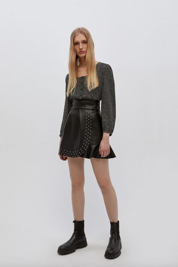 Con un bonito estampado de mini lunares, esta blusa de viscosa en color negro de Sfera viene con cierre frontal y manga ligeramente abullonada. De 15,99 euros ha pasado a costar 9,99 euros y está disponible en las tallas S, L y XL.