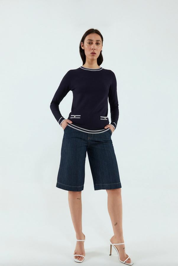 Con sus botones a contraste en color dorado y el cuello, el bajo y los puños rayados, este bonito jersey de Sfera en azul marino es uno de los más marineros, sin rayas, de nuestras firmas favoritas. Costaba 15,99 euros y ahora podemos comprarlo por 7,99 euros entre las tallas S y XL.