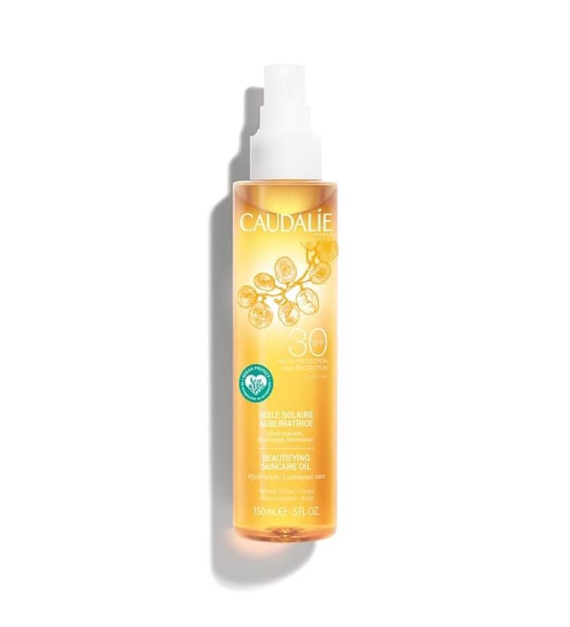 Proporciona una protección máxima frente a los rayos UVA/UVB, dejando un acabado satinado. Rico en aceite de uva nutritivo, este aceite seco nutre la piel y embellece el tono para lucir un aspecto luminoso y bronceado, sin efecto graso. Su perfume es veraniego, con notas de flores de almendro. Su fórmula es altamente biodegradable y no tóxica para el ecosistema marino.  Aceite Solar Embellecedor SPF30 de Caudalie  (23,50 €).
