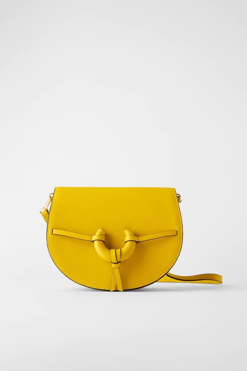 Los complementos en tono amarillo son un must para elevar cualquier look básico. Ficha esta bandolera mediana con solapa de las rebajas de Zara. Antes: 22,95 euros. Ahora: 12,99 euros.
