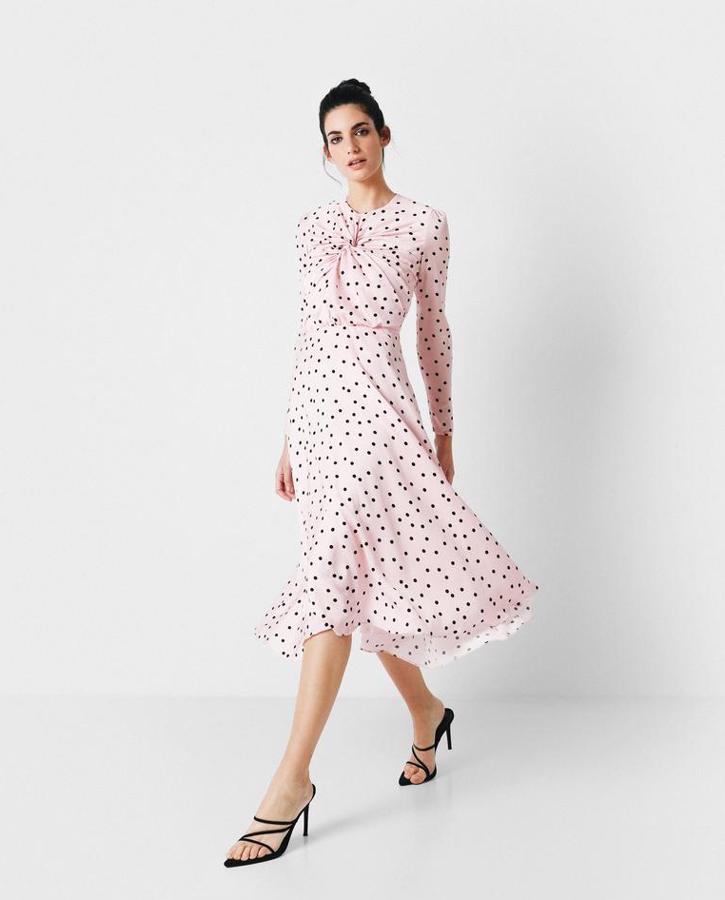 Vestido de invitada de largo midi en crepé fino de triacetato rosa con escote a la caja y manga larga. Cuerdo con nudo en el centro delantero y corte en la cintura desde donde empieza el vuelo de la falda. Un clásico de lunares que representa la esencia de nuestra diseñadora Vicky Martín Berrocal. Costaba 325 euros y ha pasado a 227 euros.