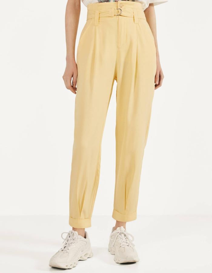 En color beige o morado, este pantalón con pinzas y cinturón cuenta con bolsillos traseros y bajo terminado en vuelta. Está rebajado a la mitad, y ahora tiene un precio de 12,99 euros.