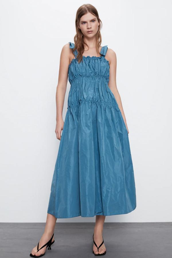 En color azul, este vestido midi de escote recto y tirantes con lazada cuenta con detalle de elástico con volantes y tiene un precio de 29,99 euros.