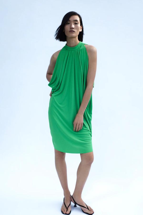 En un favorecedor color verde, este vestido amplio con cuello perkins y manga sisa cuenta con bajo asimétrico y detalle de pliegues. Tiene un precio de 15,99 euros.