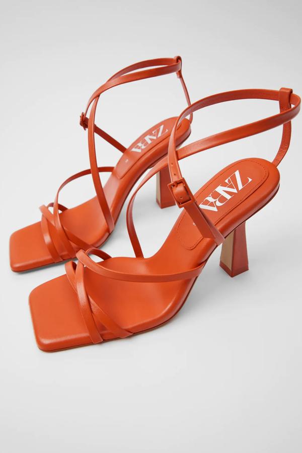 En color naranja, esta sandalia de piel con tiras finas y tacón geométrico forrado de 10 centímetros cuenta con planta acolchada y puntera cuadrada. Es de Zara, y con las rebajas tiene un precio de 39,99 euros.
