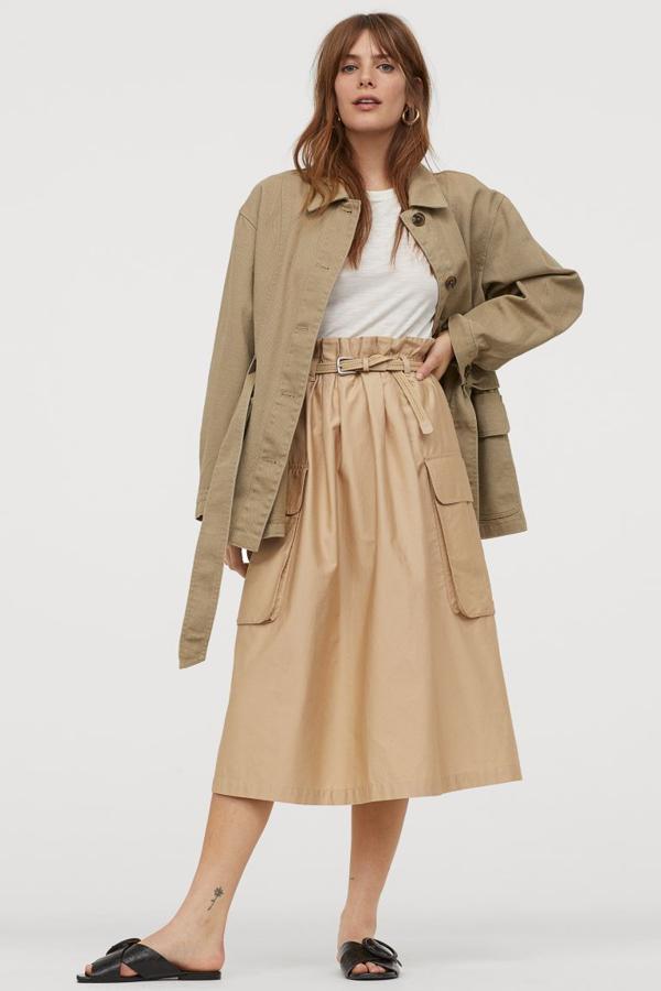Diseño evasé en satén de algodón para esta falda de H&M con largo hasta la rodilla en color beige. Con ribete de volante, cinturón trenzado extraíble y maxibolsillo parche con solapas a cada lado, costaba 29,99 euros y ha pasado a costar 14,99 euros. Está disponible entre las tallas XS y XXL.