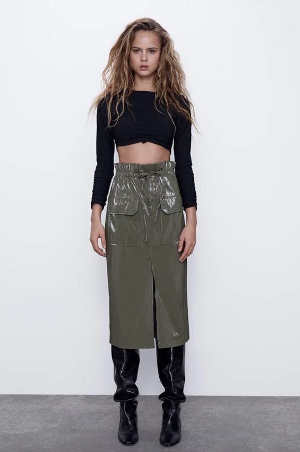 Diseño midi de tiro alto para esta falda de Zara con cintura paper bag y cierre con lazada. En caqui oscuro, con abertura frontal en el bajo, tenía un precio de 25,95 euros y ahora cuesta 15,99 euros. Está disponible entre las tallas XS y XL.