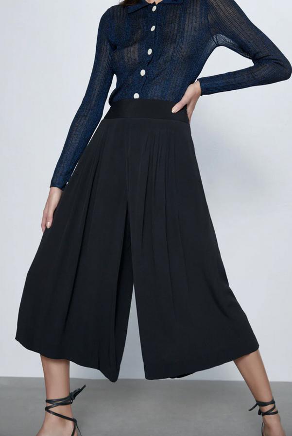 Diseño plisado en color negro para este pantalón culotte de Zara con pernera ancha y tiro alto. De 25,95 euros han pasado a costar 15,99 euros y está disponible entre las tallas XS y L.