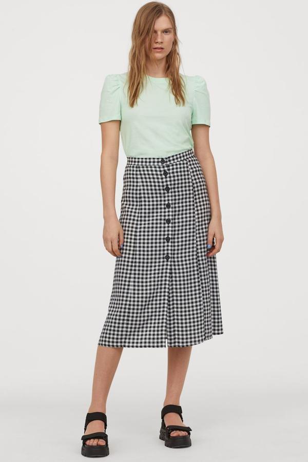 Cierre frontal de botones y estampado de cuadros blancos y negros para esta falda de H&M confeccionada en viscosa vaporosa. De 19,99 euros ha pasado a costar 14,99 euros y solo queda en las tallas 32, 34 y 36.