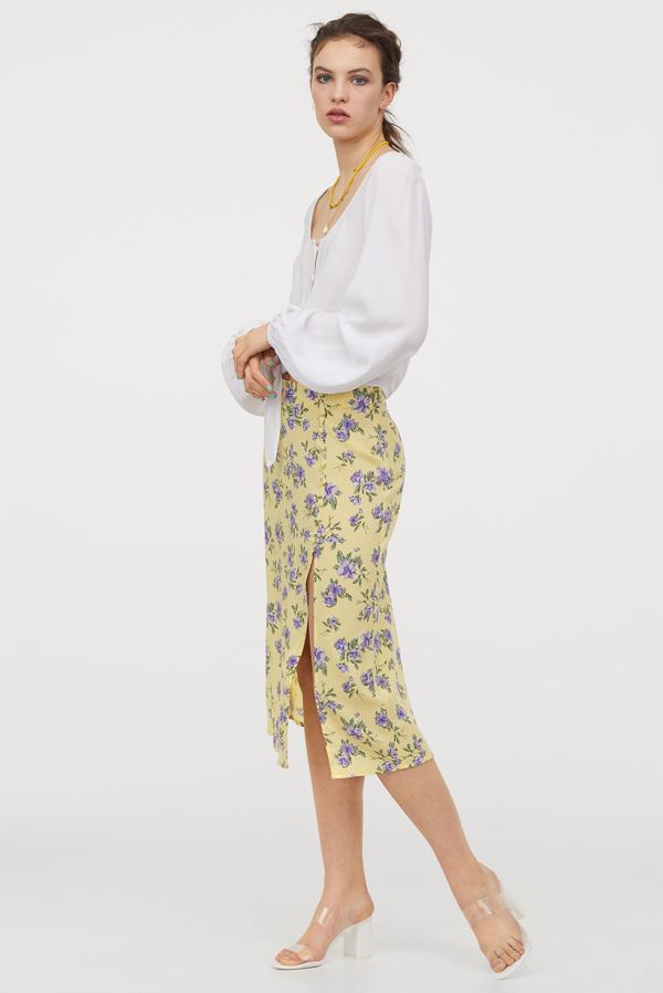 Estampado floral en tonos lilas sobre fondo blanco para esta falda midi de H&M con abertura lateral. De 19,99 euros ha pasado a costar 8,99 euros y solo queda en las tallas 48 y 50.