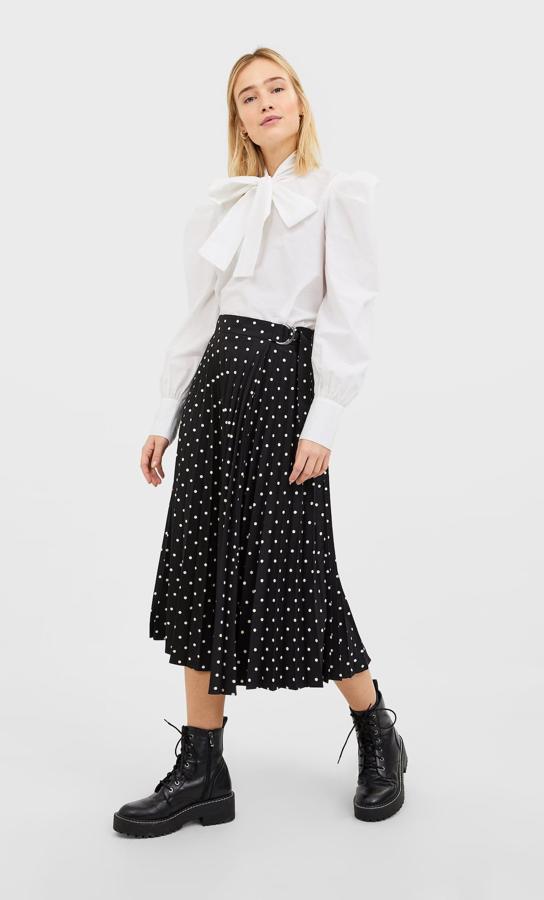 Esta falda plisada de Stradivarius viene con un bonito estampado de lunares blancos sobre fondo negro y un cierre lateral de cinturón con hebilla plateada. De 25,99 euros ha pasado a costar 12,99 euros y está disponible en las tallas S, M y L.