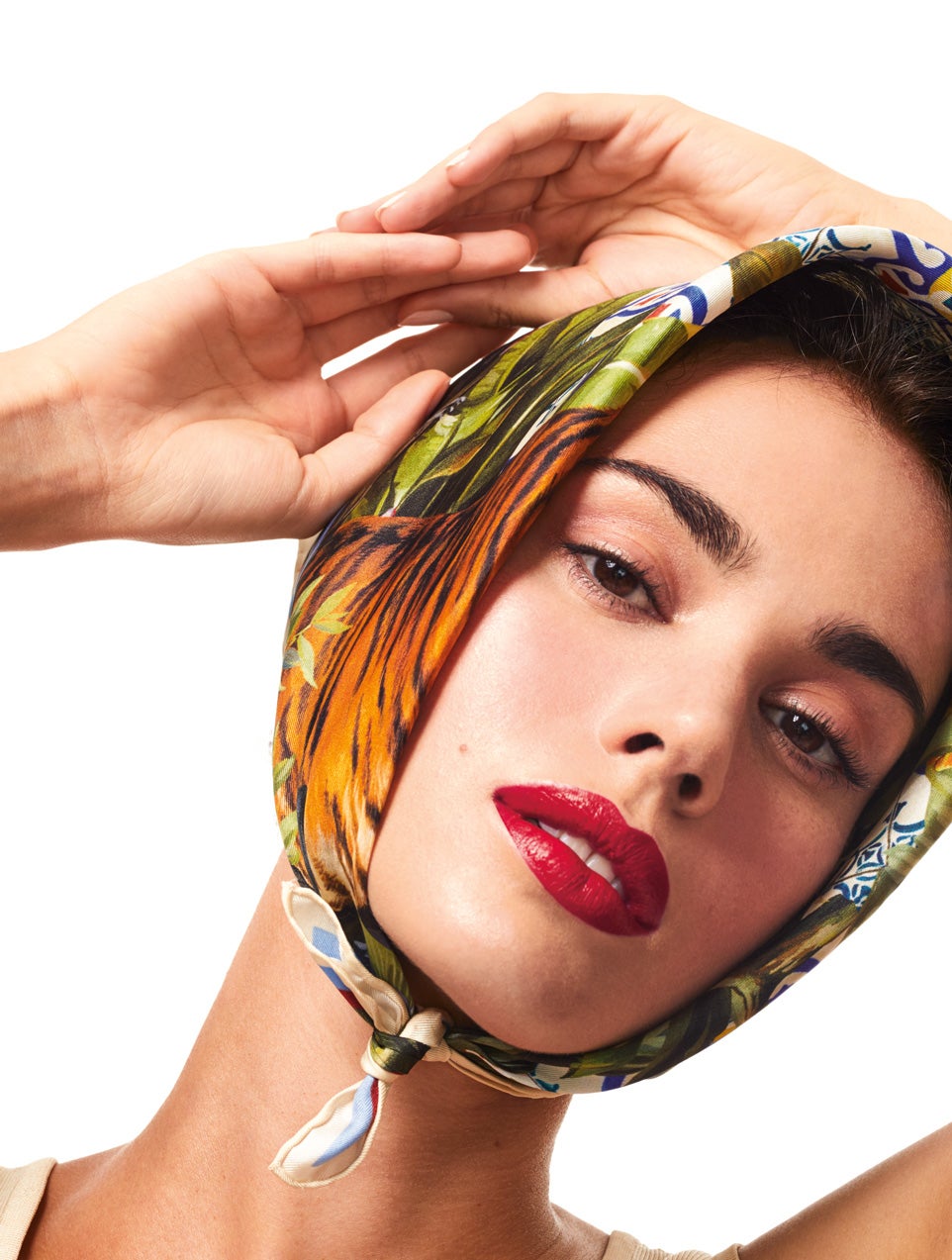 Los rojos, jugosos y perfectamente dibujados, adquieren más relevancia. The Only One Lipstick DGLover 630 de Dolce & Gabbana Beauty. Top de seda sin manga, de Hermès; y pañuelo de Dolce & Gabbana.