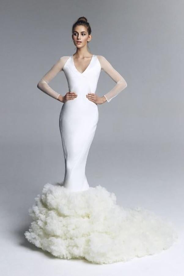Vestido de novia realizado en crepe combinando brillos y mates en los cortes del cuerpo. Escote en V con manga de tul elástica y falda de garruchas de tul seda bordadas en volante y cola. Rebajado de 2.350 a 940 euros.