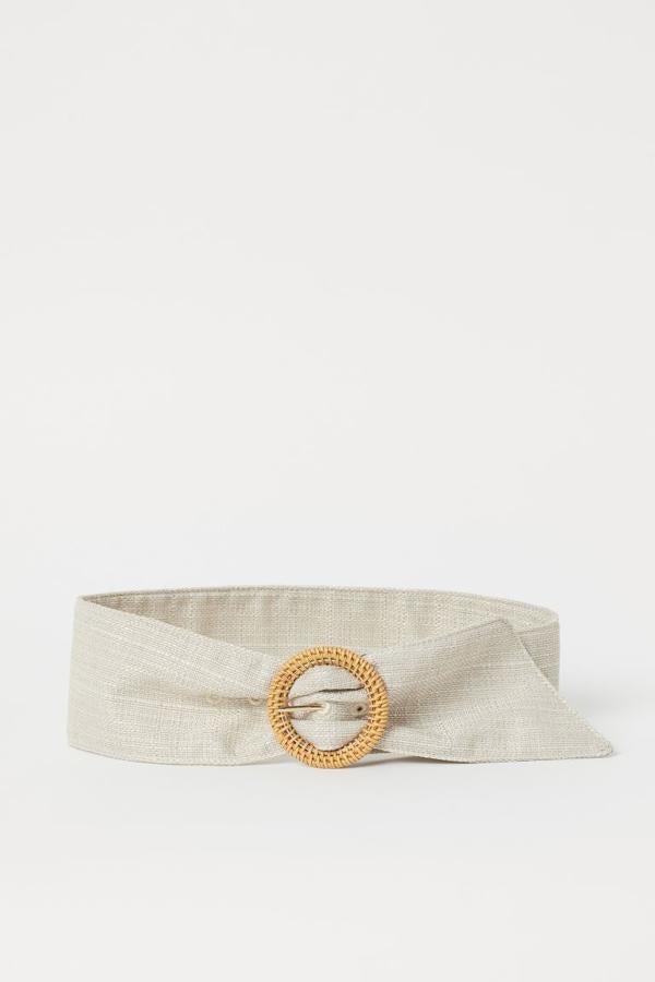 En H&M también han apostado por los diseños en tonos beige y este cinturón ancho en tejido grueso es un buen ejemplo. Con hebilla redonda de metal revestida en ratán, cuesta 17,99 euros y está disponible entre las tallas XXS y XL.