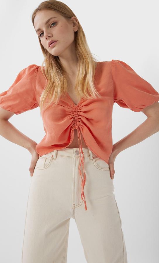Blusa en color coral con fruncido en el pecho y manga corta, rebajada de 17,99 a 9,99 euros.