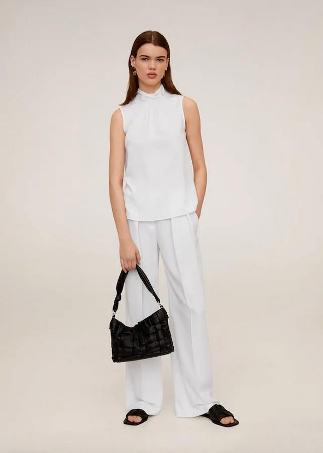 Cuello perkins y cierre de lazo decorativo en la espalda para esta blusa blanca sin mangas con acabado satinado y detalle fruncido en el cuello. De 25,99 euros ha pasado a 12,99 euros y está disponible en las tallas S, M y L.