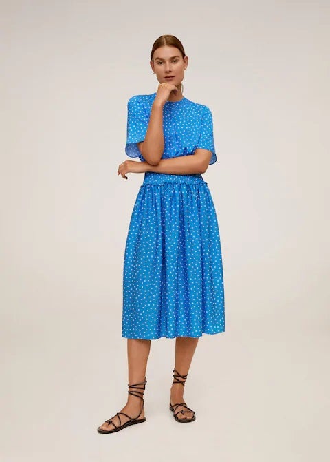 Vestido midi con estampado de lunares blancos, cintura elástica y tejido fluido. Rebajado a 22,99 euros. Antes: 49,99 euros.