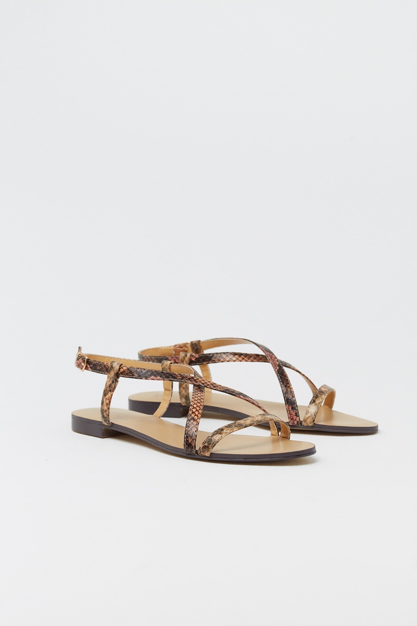 Sandalais de tiras cruzadas con suela plana y estampado de serpiente. De las rebajas de Sfera por 11,99 euros.