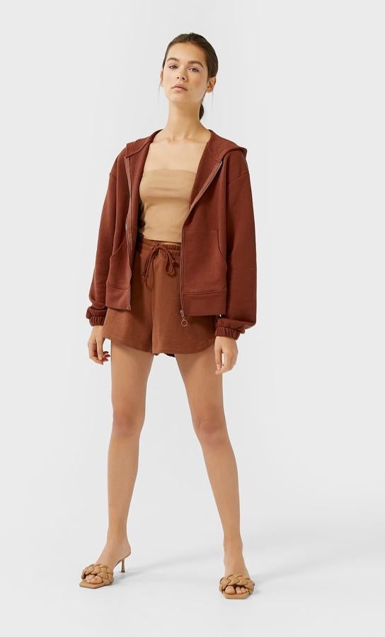 Esta sudadera con capucha y manga larga con cierre delantero de cremallera a tono es una de las muchas propuestas de Stradivarius en marrón chocolate. Tiene un precio de 17,99 euros y está disponible en las tallas S, M y L.