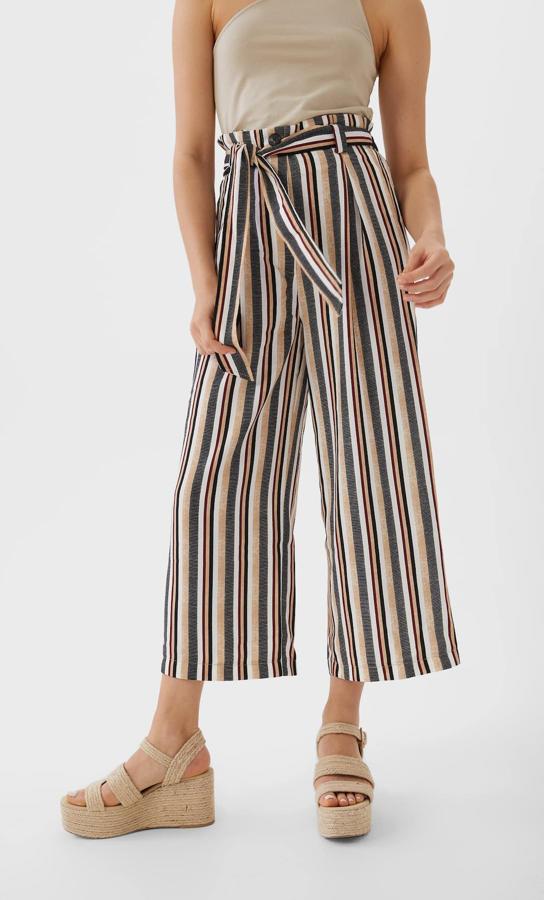Estampado de rayas en tonos beige y azules para este pantalón culotte fluido con lazada a tono. De 15,99 euros ha pasado a costar 12,99 euros y está disponible únicamente en la talla XS.