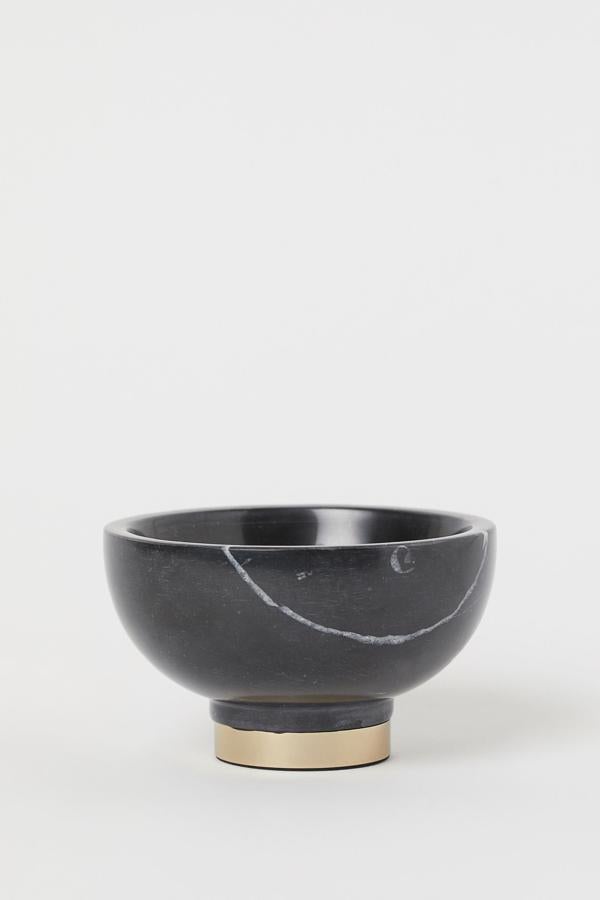 Ester bol de mármol pequeño en color negro con pie de metal y goma en la base tiene un diámetro de 12 centímetros y una altura de 7,5. Ahora cuesta 12,99 euros.