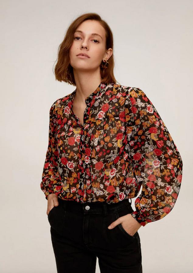 En tejido semitransparente, con cuello redondo y mangas largas abullonadas, esta blusa de Mango con estampado de flores en tonos rojos y naranjas costaba 29,99 euros y ahora está disponible entre las tallas XS y L por 9,99 euros.