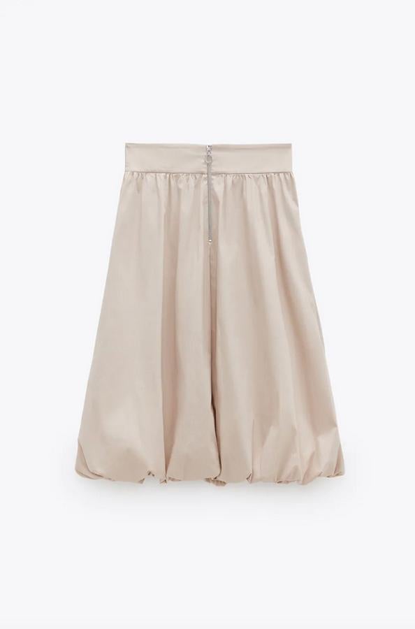 En color beige y con acabado abullonado, esta falda midi en diseño globo vine con cierre frontal con cremallera metálica. Cuesta 29,95 euros y está disponible entre las tallas XS y XL.